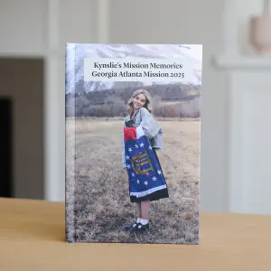 A finished hardbound missionary book with a Georgia Atlanta Mission cover standing on a table