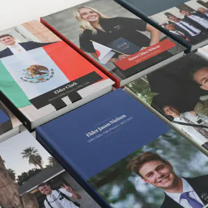 An overhead view of many finished missionary books showing a range of cover designs