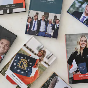Several finished missionary books with different mission covers arranged on a marble surface